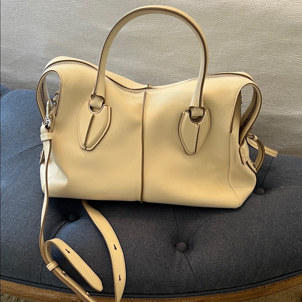 Tod’s cream colored purse with shoulder strap.